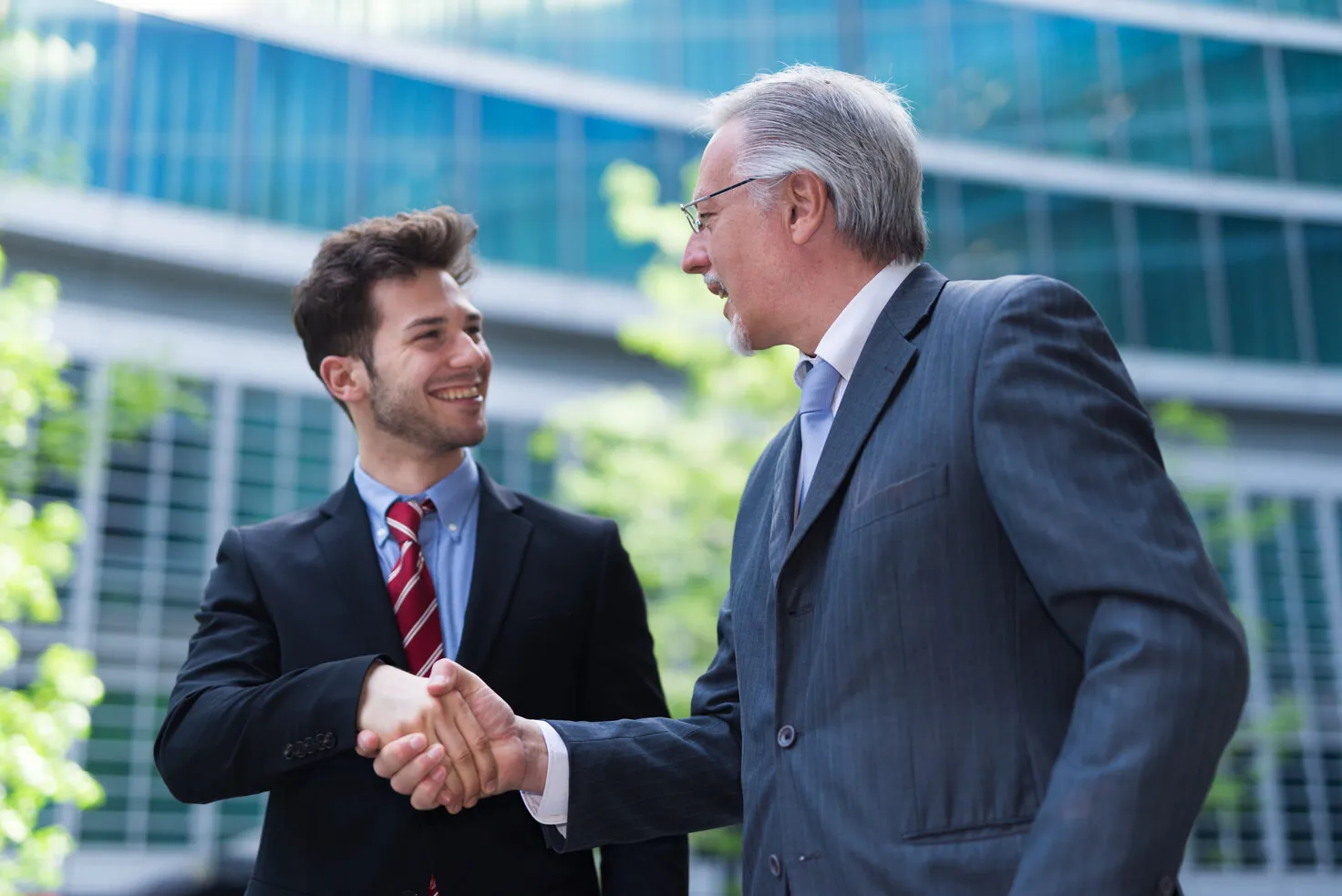 Two visitors shaking hands outside an office building